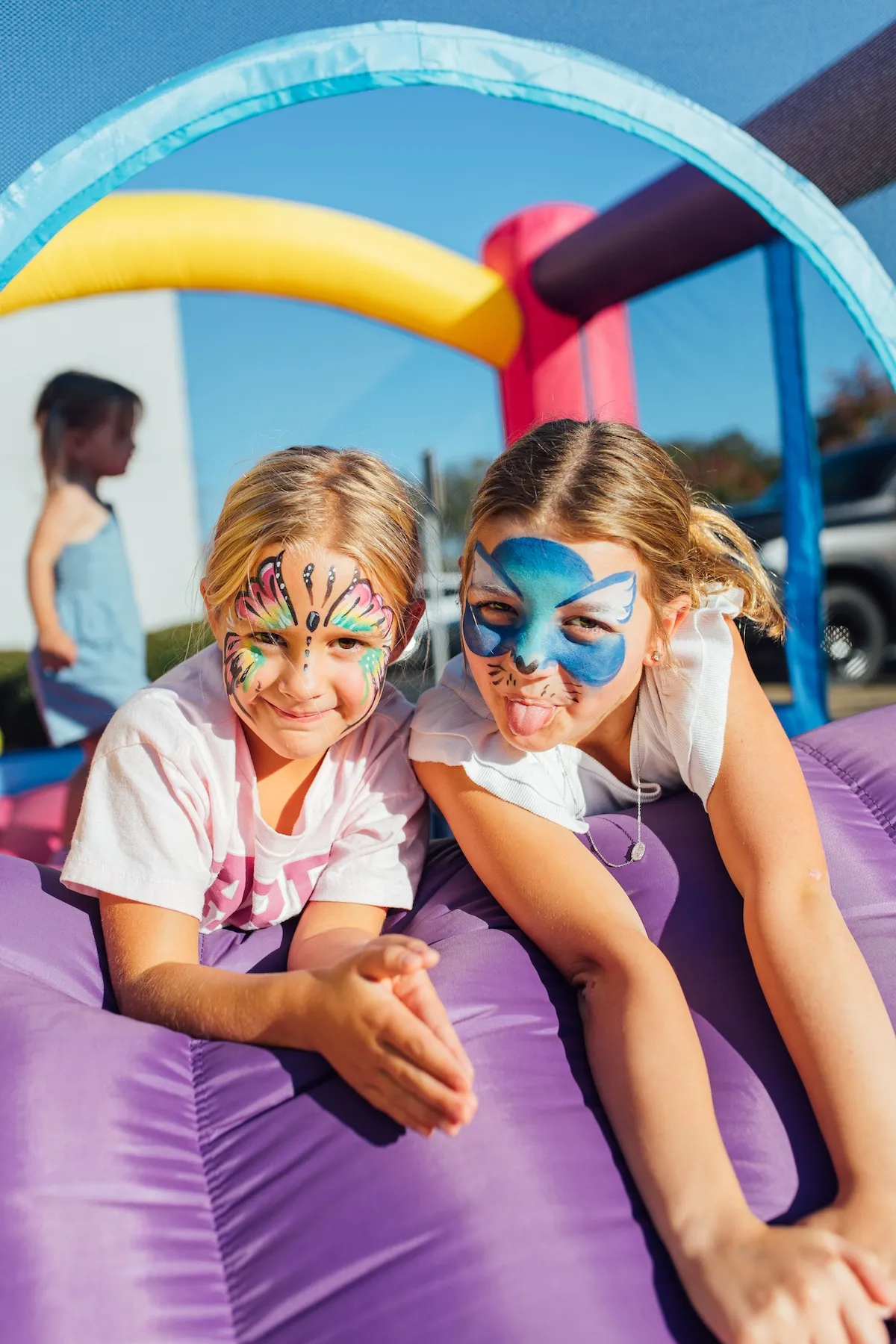 Children enjoying inflatable play area with face paint at Jubilee Church community event